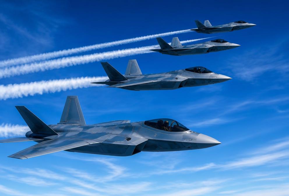 Fighter jets flying in formation across a bright blue sky