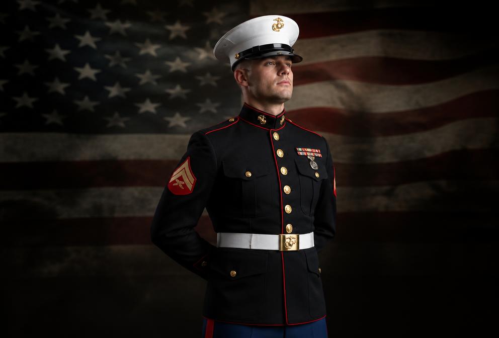 Marines in scarlet and gold dress uniforms marching in formation